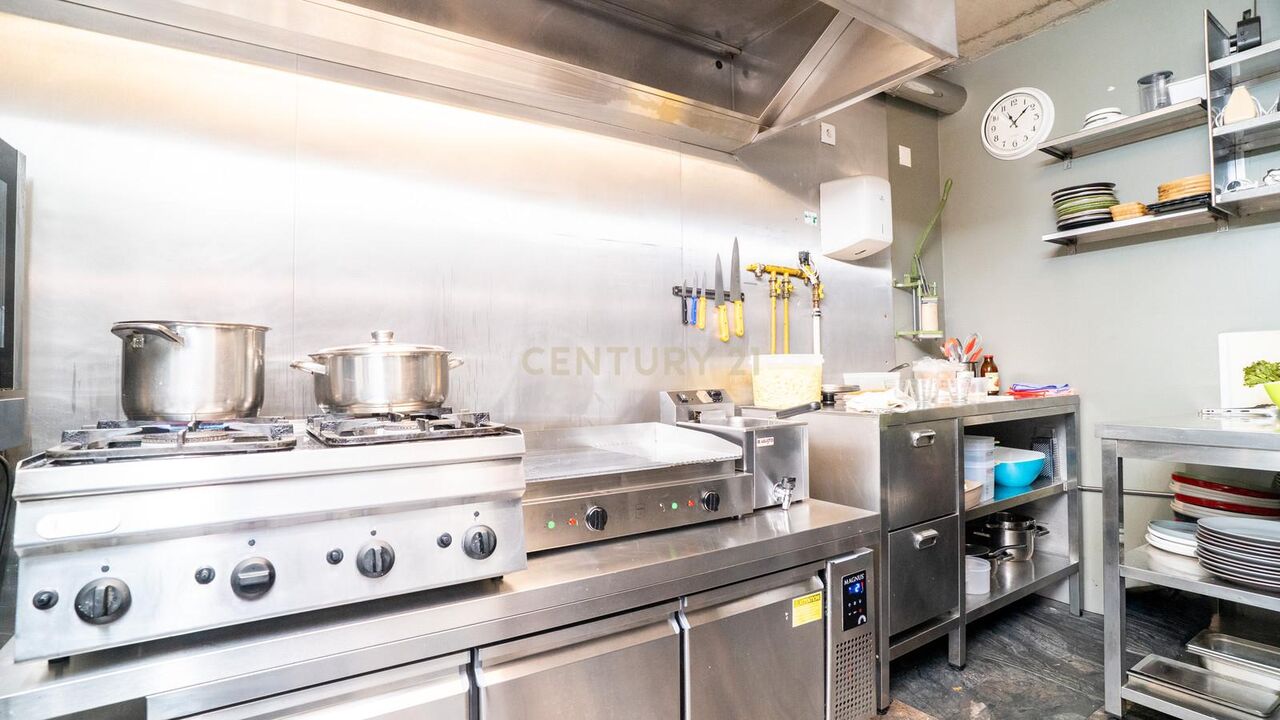 Kitchen cooking line with gas burners, griddle and extraction hood