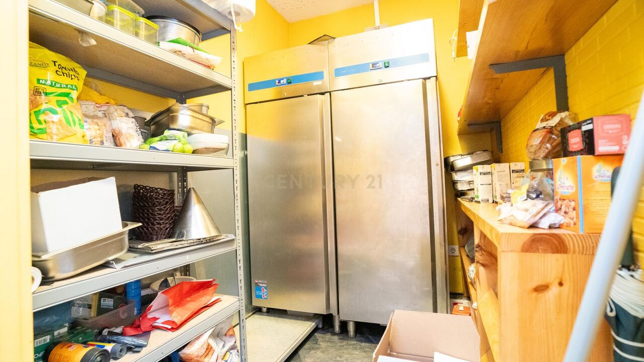 Dry store with shelving and two upright fridges